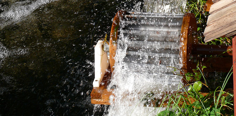 Vatten som skvätter i en vattenkvarn i en å.
